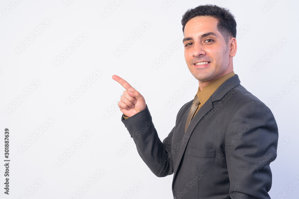 Portrait of happy Persian businessman in suit pointing finger Portrait of happy Persian businessman in suit pointing finger
