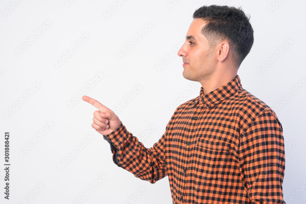 Profile view of handsome Persian hipster man pointing finger Profile view of handsome Persian hipster man pointing finger