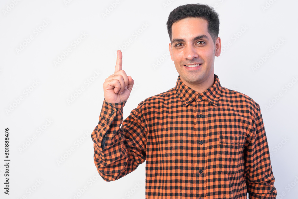 Portrait of happy Persian hipster man pointing up Portrait of happy Persian hipster man pointing up