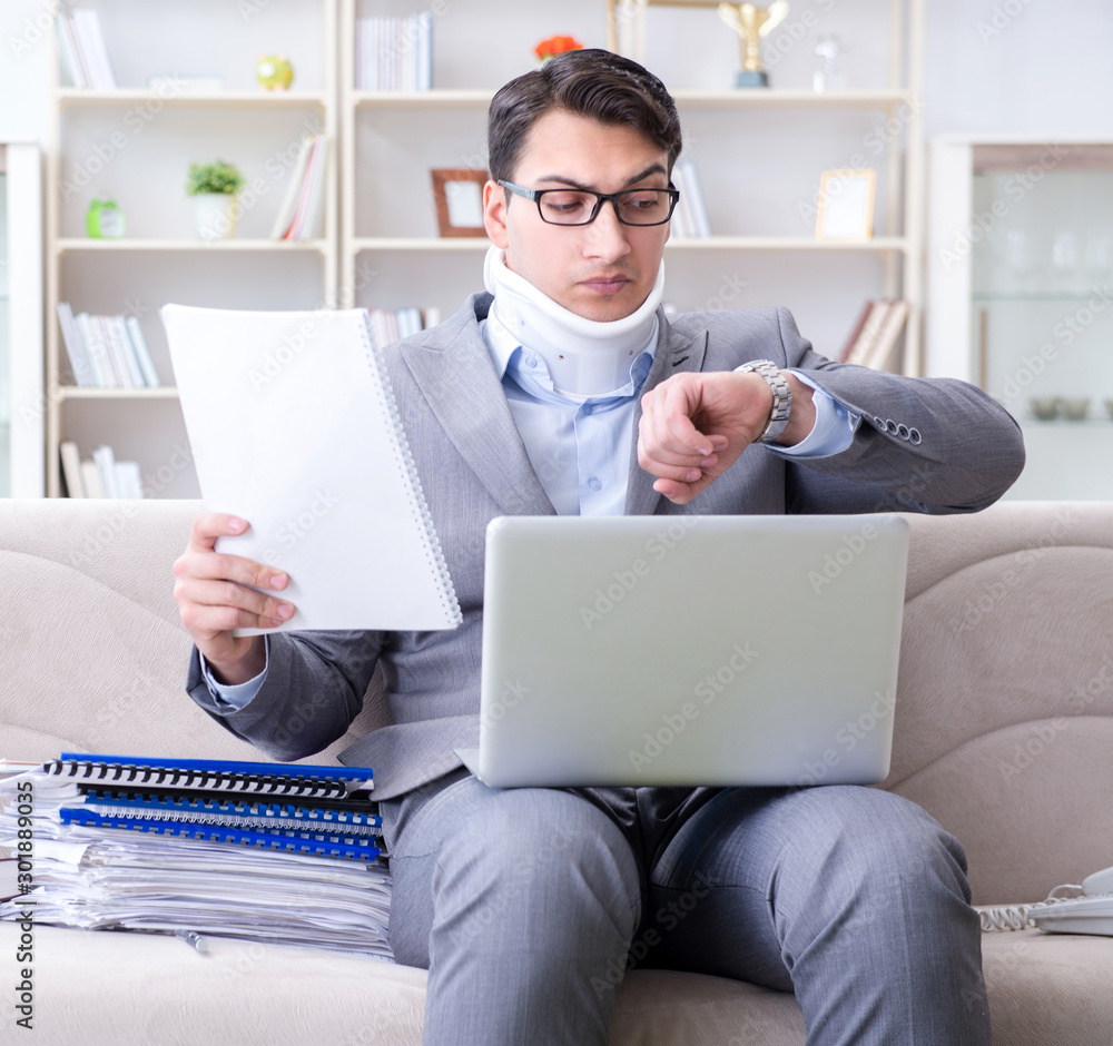 Man in neck brace cervical collar working from home teleworking Man in neck brace cervical collar working from home teleworking