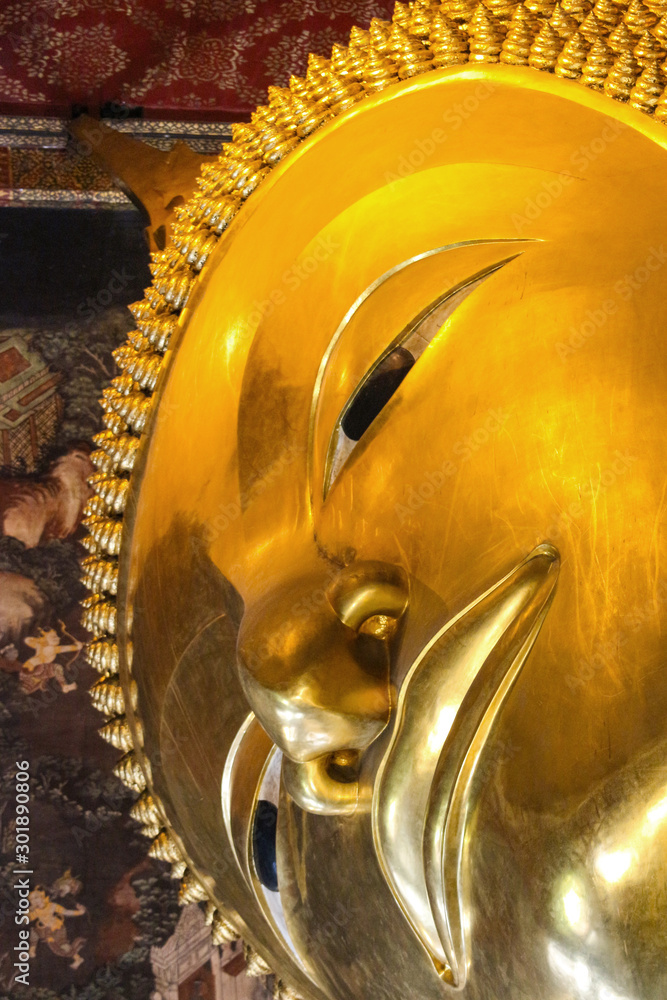 Face part of Big Golden reclining Buddha statue at Wat pho Thailand.