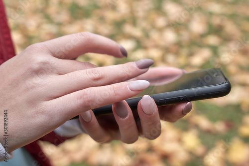 Girl hand touching screen on modern mobile smart phone.