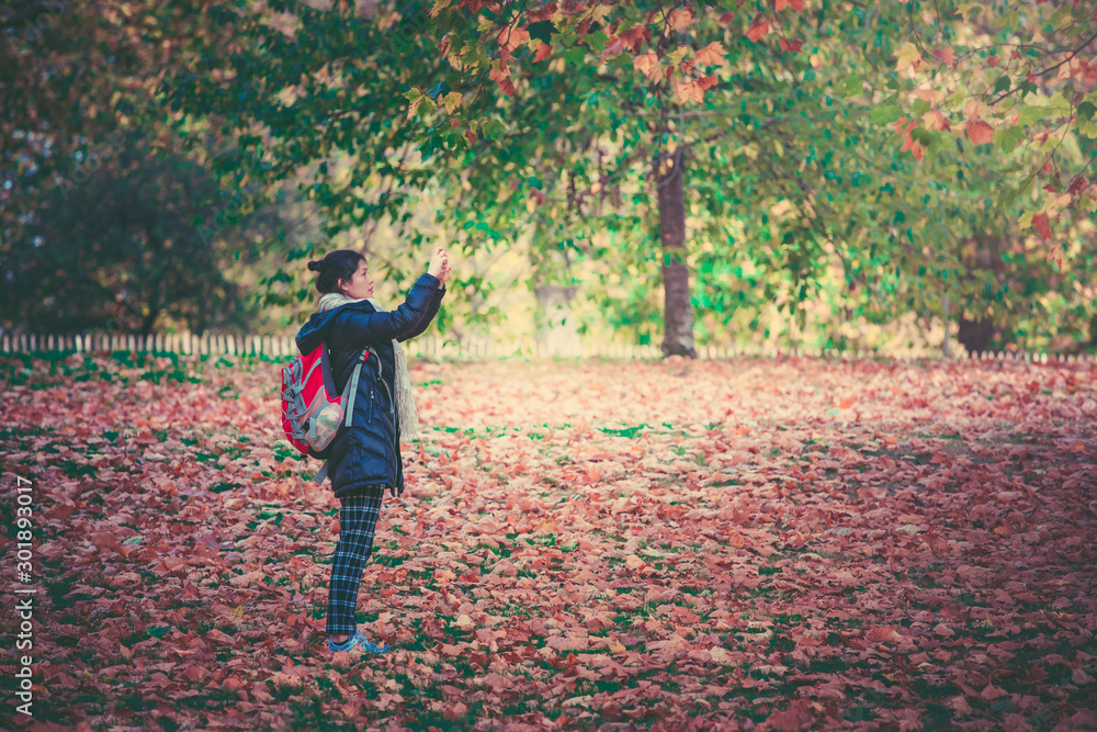 Woman taking photos in Hyde Park in fall season