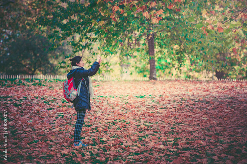 Woman taking photos in Hyde Park in fall season © YiuCheung