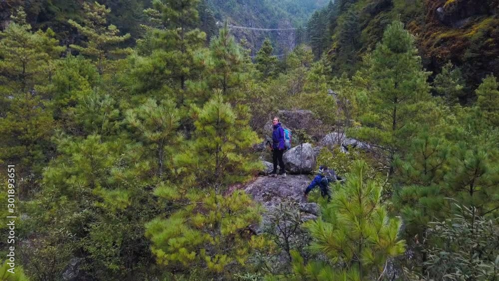 Aerial: Fly Cam (tracking shot) follow at Hikers on a forest trail along riverside. Active sport in the forest of Nepal Aerial: Fly Cam (tracking shot) follow at Hikers on a forest trail along riverside. Active sport in the forest of Nepal