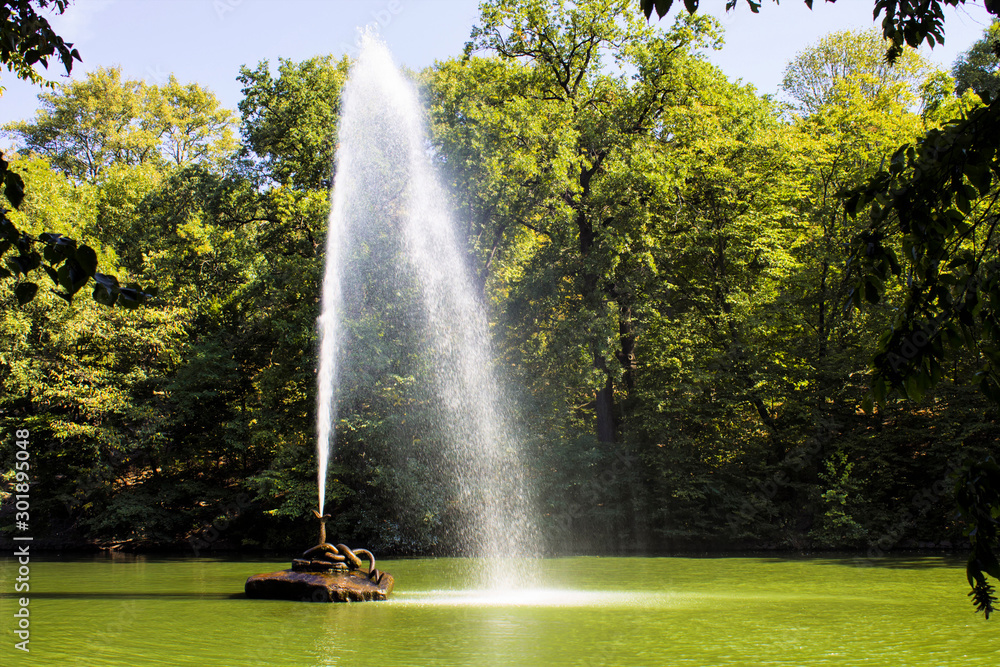 Fototapeta premium Fountain on a pond on a bright sunny day sofiyevsky park.