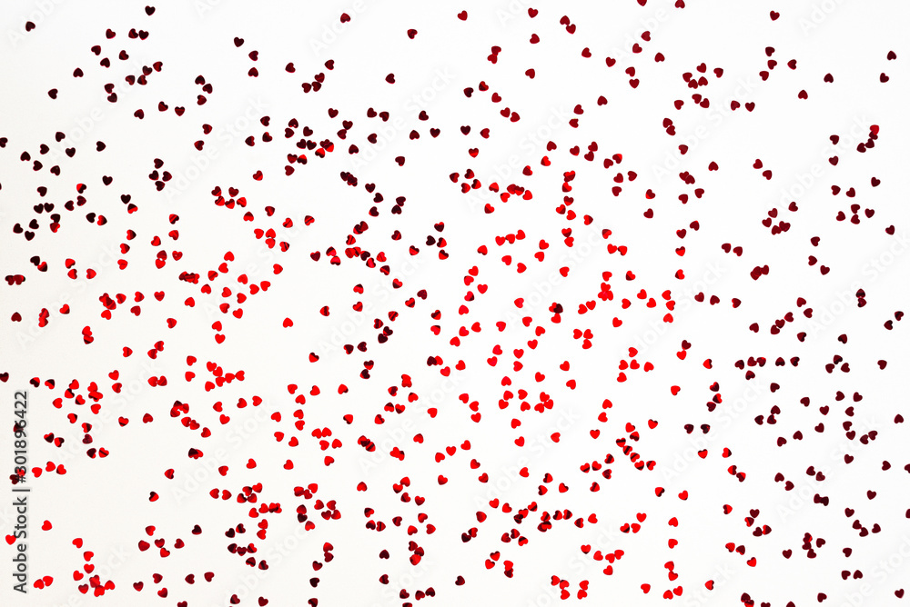 Valentine's Day background - scattered heart shaped confetti over white background.