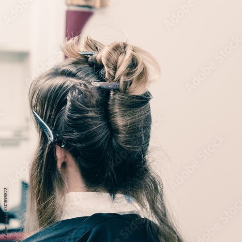 Closeup of professional stylist using brush to apply dye on clients hair