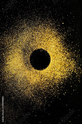 Festive New Year and Christmas shiny glitter layout.Vibrant background with twinkle lights.Gold glitter in the shape of a circle on a black background.brilliant mockup