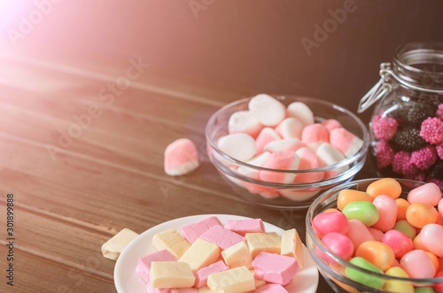 multi-colored candies in a plate, bank and bowls, close up