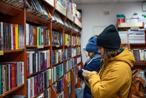 woman choosing book at bookstore