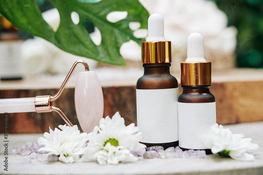 Quartz massage roller with bottles of serums or oils for spa procedure Quartz massage roller with bottles of serums or oils for spa procedure