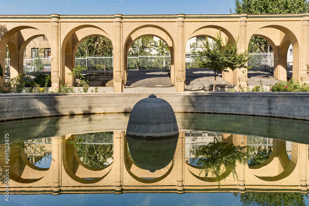 Arch walls reflection in pool water, Masoudieh historic mansion, Tehran, Iran