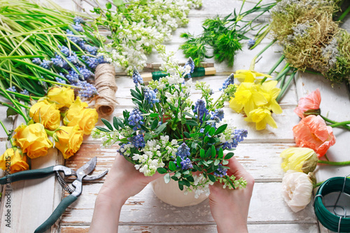 Florist at work  woman arranging bouquet of springtime flowers.