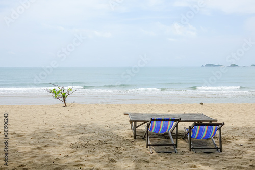 Beach chair on white sand with sea wave and sunny. Relaxing on the beach.