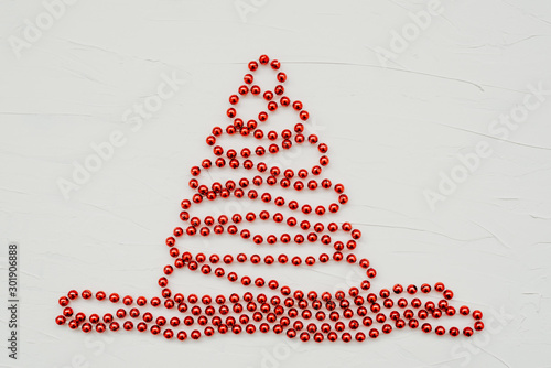 Christmas tree made of red beads on white texture background. Blank for cards, greetings, invitations