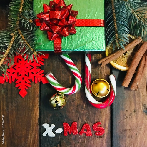 Christmas Vintage Background. Christmas decorations and congratulation in shiny letters X-Mas over old dark wooden background