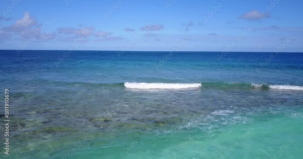 Caribbean coral reef, open ocean with seafoam, bright blue sky and white clouds Caribbean coral reef, open ocean with seafoam, bright blue sky and white clouds