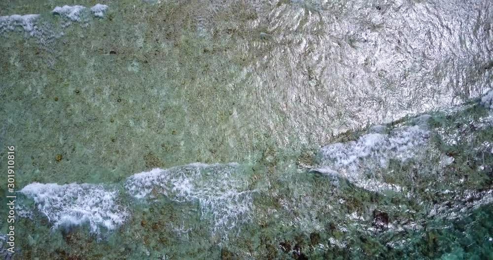 Top down drone shot of waves creating foam on an island surface with interesting terrain in fiji Top down drone shot of waves creating foam on an island surface with interesting terrain in fiji
