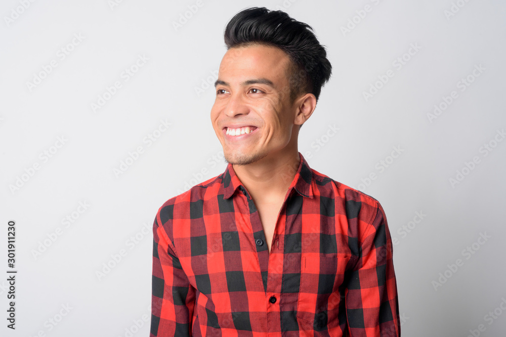 Face of happy young Asian hipster man thinking