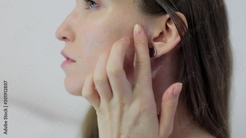 Young well-groomed woman of mixed race. Close-up of a facial plan, girl applies massage, cream and cosmetic wipes. Young well-groomed woman of mixed race. Close-up of a facial plan, girl applies massage, cream and cosmetic wipes.