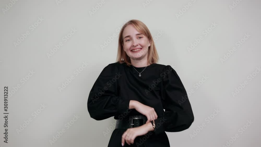 Surprised cheerful young woman in black dress, looking camera, spreading hands isolated on white background in studio. People sincere emotions, lifestyle concept. Surprised cheerful young woman in black dress, looking camera, spreading hands isolated on white background in studio. People sincere emotions, lifestyle concept.