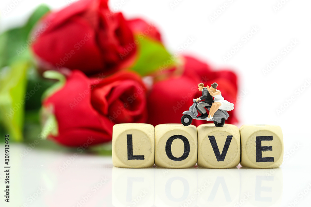 Fototapeta premium Miniature people : Couple lover and Love text wooden blocks with rose and gift box,Lover concept.