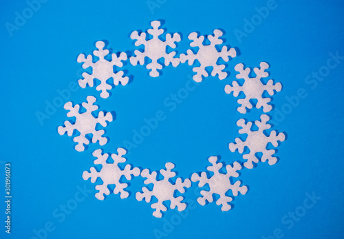 Christmas or winter frame. Circle snowflakes on a blue background. Flat lay  top view  space for text.