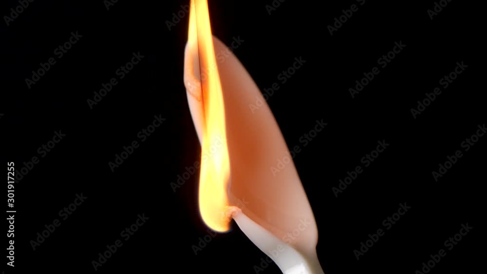 Flame burns isolated plastic spoon against black background. Concept for global warming and sea pollution. Flame burns isolated plastic spoon against black background. Concept for global warming and sea pollution.