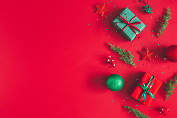 Christmas composition. Gift box, christmas decorations on red background. Flat lay, top view, copy space