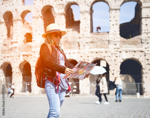 Woman tourist with map at Rome in front of Colosseum, Italy.