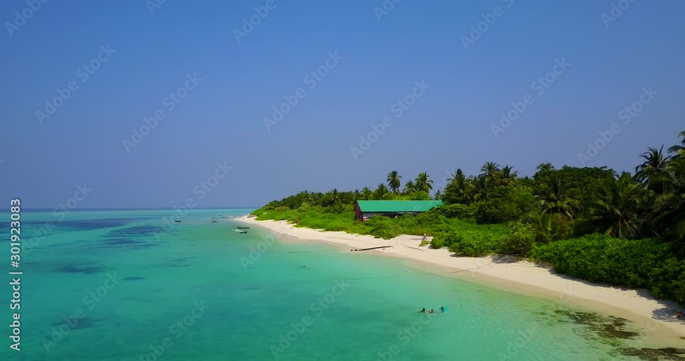 Polluted seawater near tropical bay where fishing boats anchoring close to barracks of fishermen into lush vegetation