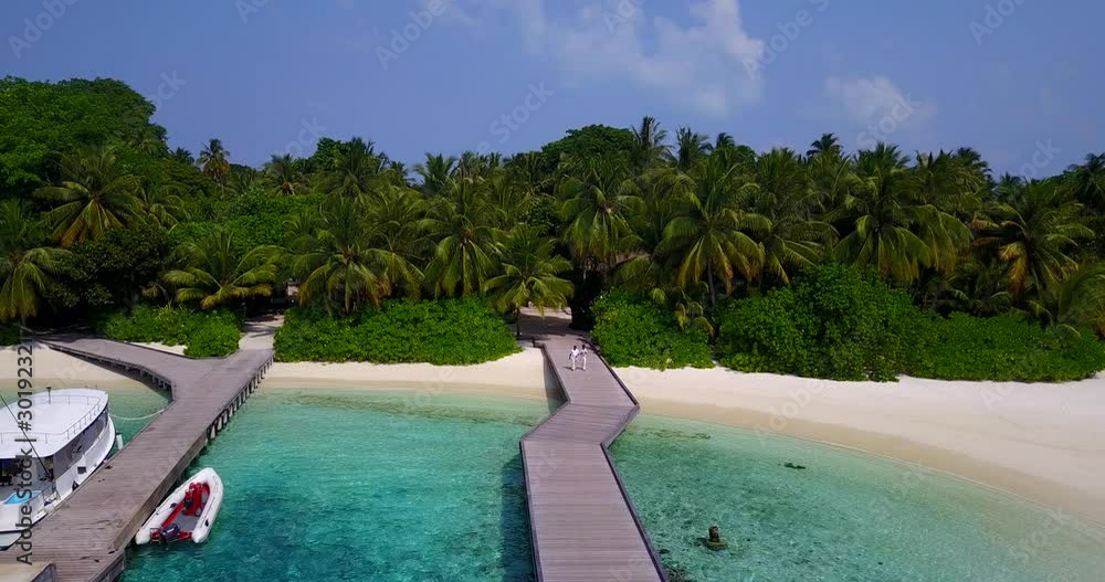 Boats anchored on docks of beautiful tropical island full of palm trees and vegetation where many resorts are built Boats anchored on docks of beautiful tropical island full of palm trees and vegetation where many resorts are built