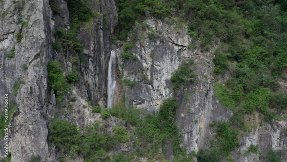 Drone flying past ridge, revealing small waterfall Drone flying past ridge, revealing small waterfall