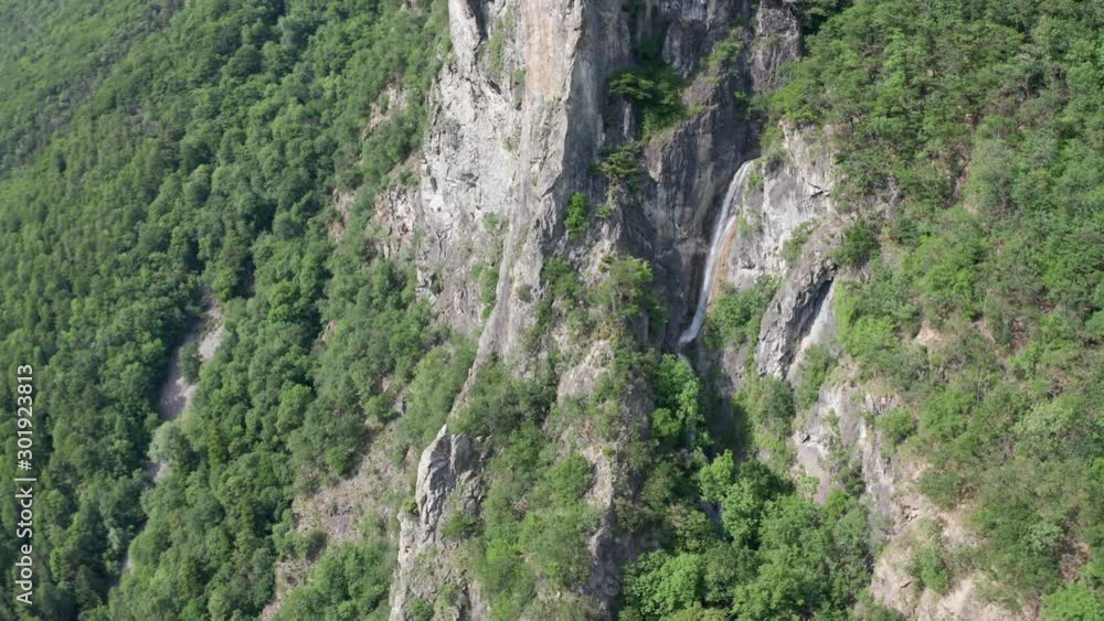 Aerial of beautiful green mountain ridge with a small waterfall Aerial of beautiful green mountain ridge with a small waterfall