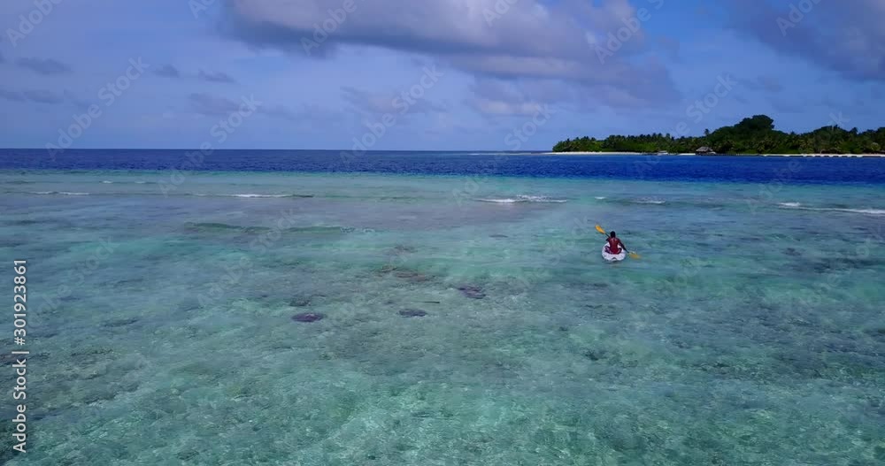 Guy with kayak exploring shallow waters of lagoon near tropical island in Caribbean, watching coral reefs and tropical fish Guy with kayak exploring shallow waters of lagoon near tropical island in Caribbean, watching coral reefs and tropical fish