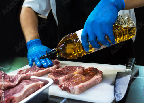 Butcher Cutting Raw Meat With Knife in the kitchen