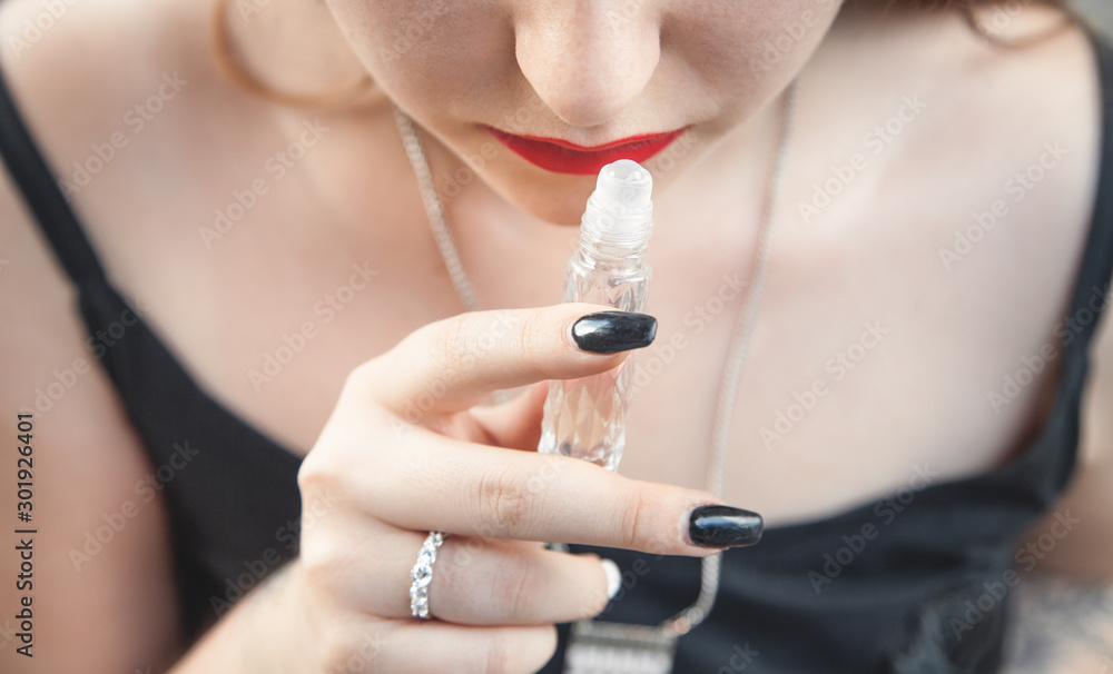 Beautiful girl smelling perfume.