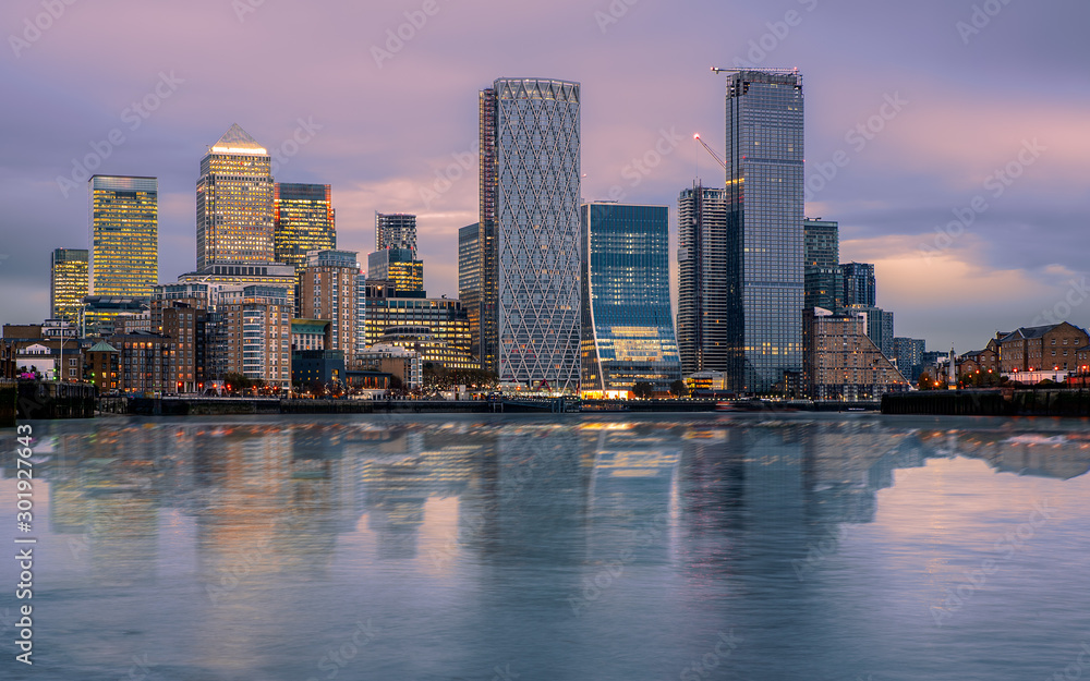 Canary wharf cityscape. The buildings are reflected in Thames river’s water. Canary wharf is the business districet in London City UK. Wihtout company logos