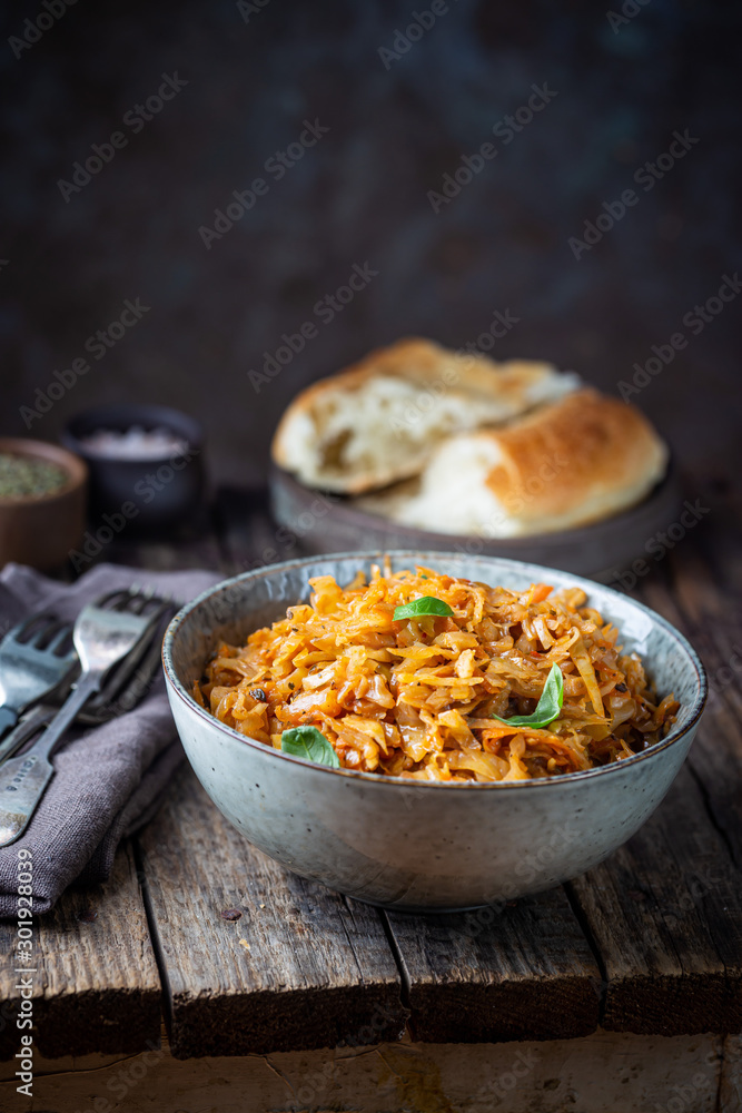 Stewed or braised cabbage served in a bowl on Rustic wooden background, close up Stewed or braised cabbage served in a bowl on Rustic wooden background, close up