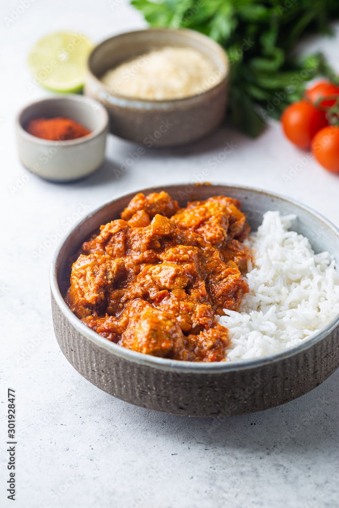 Chicken meat with tikka masala sauce, spicy curry food in a bowl with rice and seasonings Chicken meat with tikka masala sauce, spicy curry food in a bowl with rice and seasonings