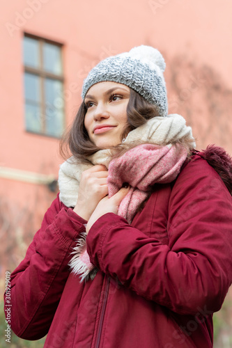 Beautiful young woman with eat muffs and scarf in Winter