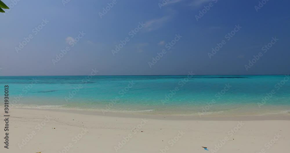 Wide wonderful seascape of dusty sky over brighten turquoise lagoon washing white sand seen across leaves of tropical plants in Bahamas Wide wonderful seascape of dusty sky over brighten turquoise lagoon washing white sand seen across leaves of tropical plants in Bahamas