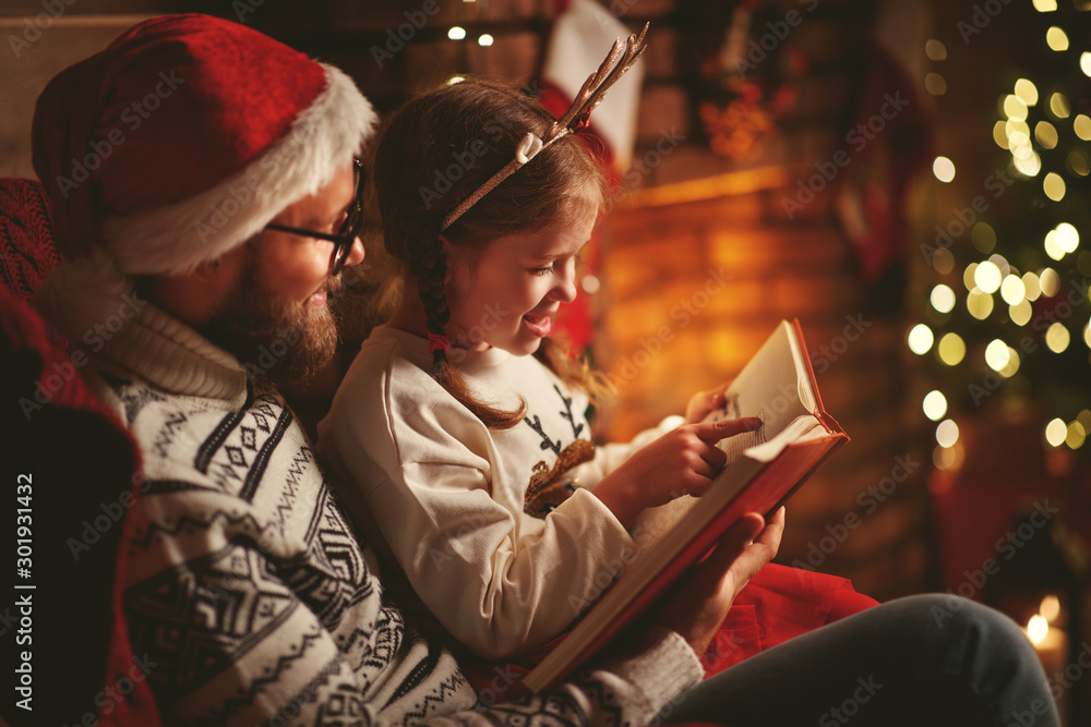 Christmas Eve. family father and child reading magic book at home . Christmas Eve. family father and child reading magic book at home .