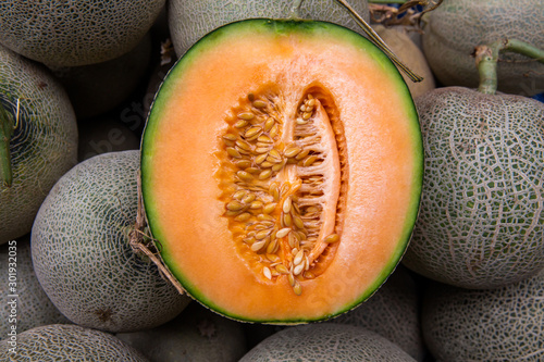 Cantaloupe cut half on pile of cantaloupe melon
