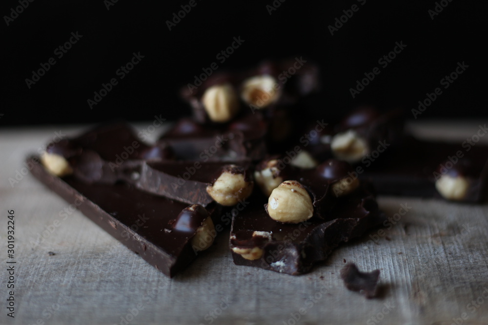 broken pieces of black chocolate with nuts broken pieces of black chocolate with nuts
