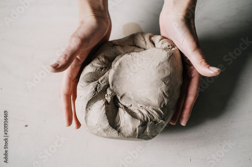 Tablou canvas Female potter hands working with clay in workshop