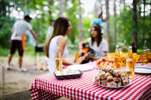 Group of friends camping and having a barbecue in nature