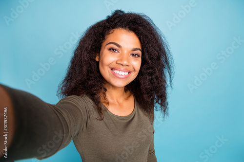 Close up photo of positive cheerful afro american girl feel fun on holidays free time weekends make selfie wear casual style jumper isolated over blue color background