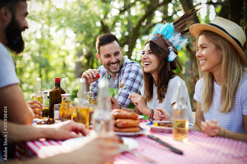 Group of happy friends eating and toasting at garden barbecue Group of happy friends eating and toasting at garden barbecue